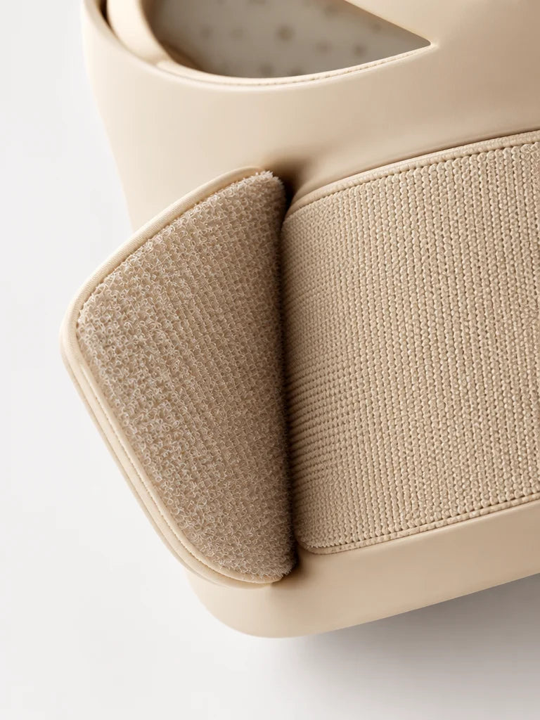 A macro photograph of the exact beige mask’s rear adjustable hook-and-loop strap from the reference,